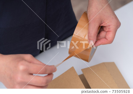 Hands of a woman doing packing work 73505928