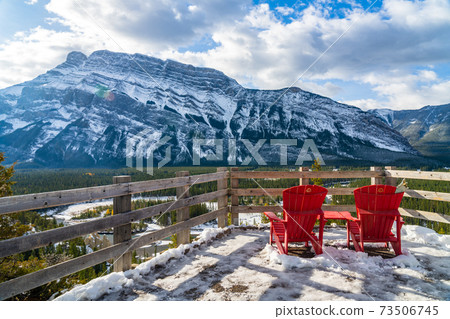 Red chair look over Mount Rundle in snowy winter sunny day. Banff National Park beautiful landscape. Hoodoos Viewpoint, Canadian Rockies. 73506745