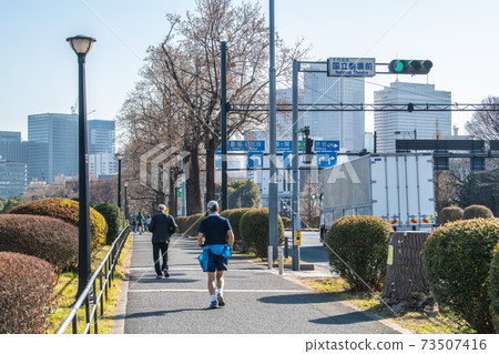 Tokyo cityscape of Japan under a state of emergency. Runners running around the Imperial Palace = January 16th, near "National Theater" 73507416