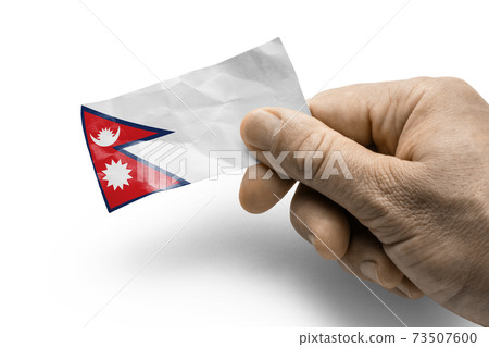 Hand holding a card with a national flag the Nepal Hand holding a card with a national flag the Nepal 73507600