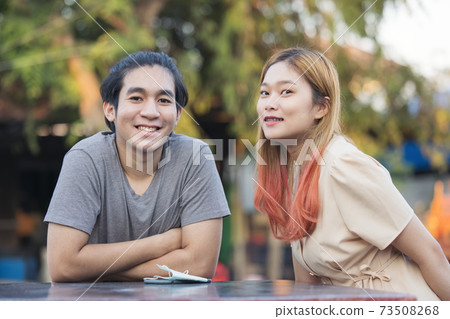 Young asis couple talking outdoor Young asis couple talking outdoor 73508268