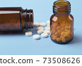Various medicine. White round pills and two pill bottle 73508626