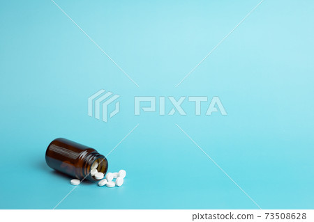 Various medicine. White round pills and pill bottle 73508628