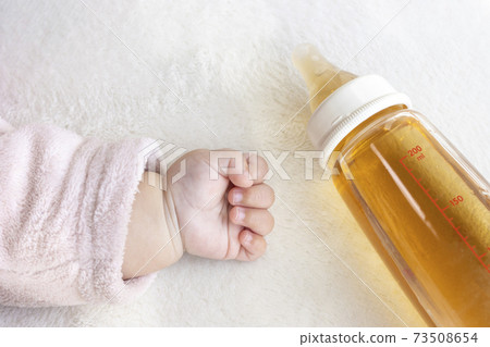 Baby's hand and baby bottle with barley tea (0 years old, 6 months old, girl, Japanese) Baby's hand and baby bottle with barley tea (0 years old, 6 months old, girl, Japanese) 73508654
