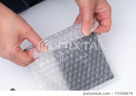 Hands of a woman doing packing work Hands of a woman doing packing work 73508674