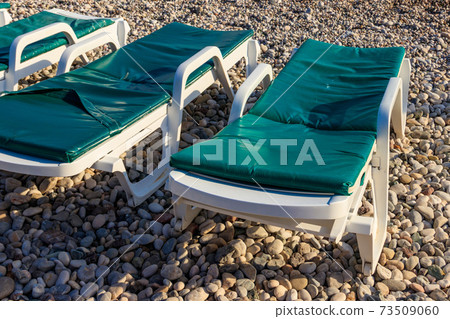 Chaise lounges on a pebble beach. Concept of rest, relaxation, holidays, resort 73509060