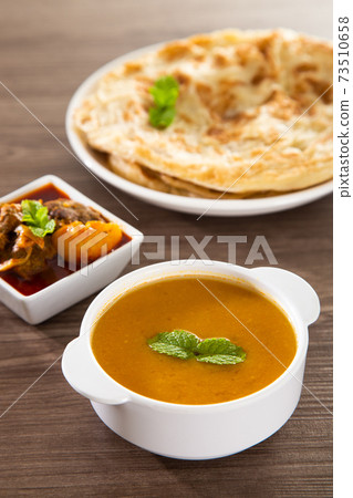 Roti Parata or Roti canai with lamb curry sauce. Roti Parata or Roti canai with lamb curry sauce. 73510658