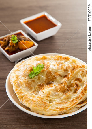 Roti Parata or Roti canai with lamb curry sauce. Roti Parata or Roti canai with lamb curry sauce. 73510659