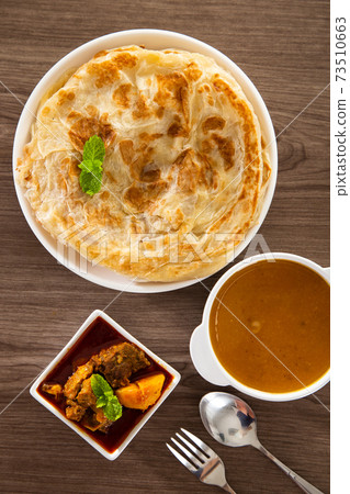 Roti Parata or Roti canai with lamb curry sauce. Roti Parata or Roti canai with lamb curry sauce. 73510663