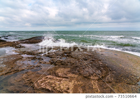 Wave splashing at the rocks, freshness on beach 73510664