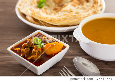 Roti Parata or Roti canai with lamb curry sauce. 73510665