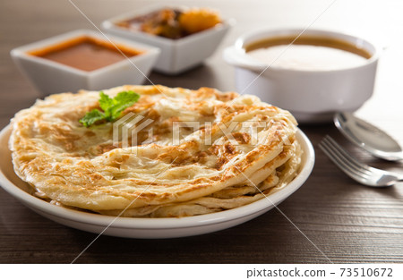 Roti Parata or Roti canai with lamb curry sauce. 73510672