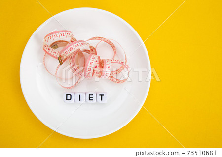 Measuring tape on a fork and knife - diet concept 73510681