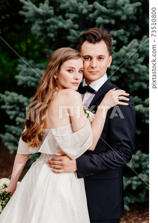outdoor wedding ceremony. Beautiful newlyweds tenderly embrace outdoor wedding ceremony. Beautiful newlyweds tenderly embrace 73510800