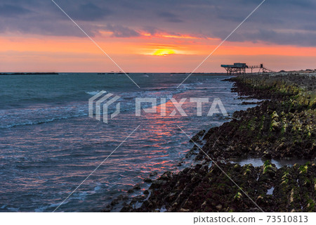 Rocky coastline on sea at sunrise Rocky coastline on sea at sunrise 73510813