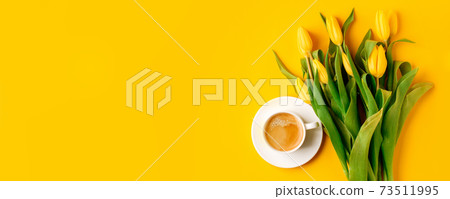 Coffee mug with bouquet of yellow tulips and copy space for notes good morning on bright yellow table, beautiful breakfast, vintage card, top view, flat lay, 8 march, woman day, mother day, romance 73511995