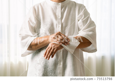 Senior woman cleaning her hands with white soft tissue paper. isolated on a white backgrounds 73513798