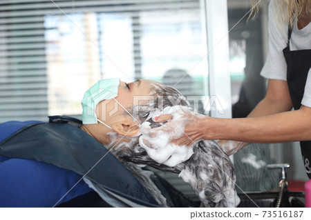 woman customer in a salon with medical masks during virus pandemic. Working with safety mask. 73516187