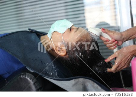 woman customer in a salon with medical masks during virus pandemic. Working with safety mask. 73516188