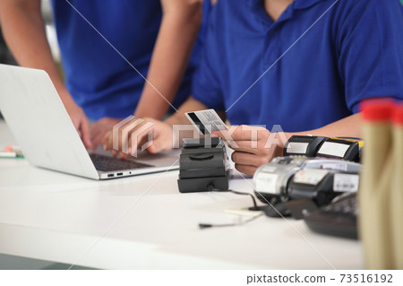 customer paying with  credit card with  technology. credit card reader machine at bar counter with  holding credit card. Focus on hands. 73516192