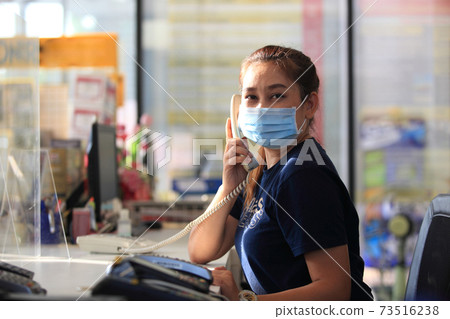 Young woman with face mask back at work in office after lockdown 73516238