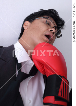Business man getting punch with boxing glove. 73516426