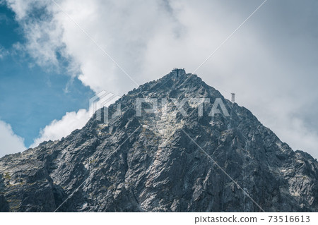 View of the Lomnicky stit peak, famous rocky summit in High Tatras, Slovakia. Cloudy windy day. 73516613