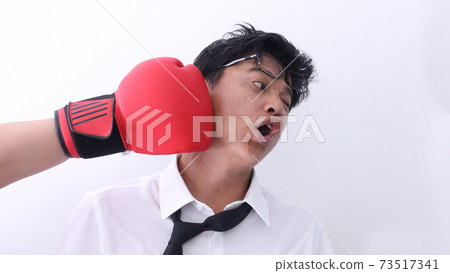 Business man getting punch with boxing glove. 73517341