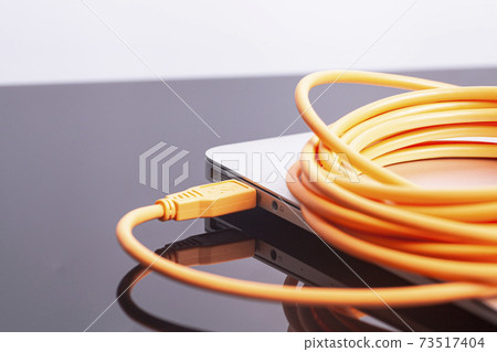laptop with orange rolled cable laptop with orange rolled cable 73517404