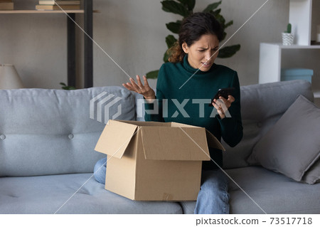 Unhappy woman use cell dissatisfied with online order Unhappy woman use cell dissatisfied with online order 73517718