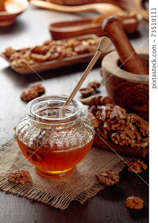 Honey and walnut on a old wooden table. Honey and walnut on a old wooden table. 73519111