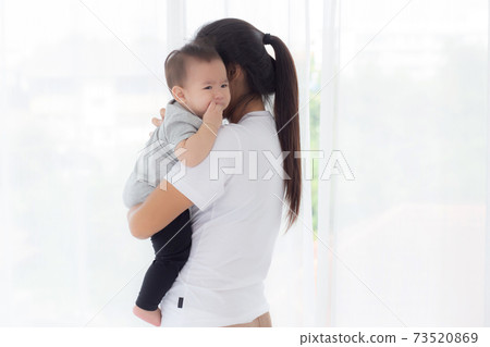 Young asian mother holding little baby girl and walking together in the bedroom at home. Young asian mother holding little baby girl and walking together in the bedroom at home. 73520869