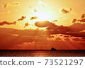 First sunrise from the sea and silhouette of a fishing boat 73521297