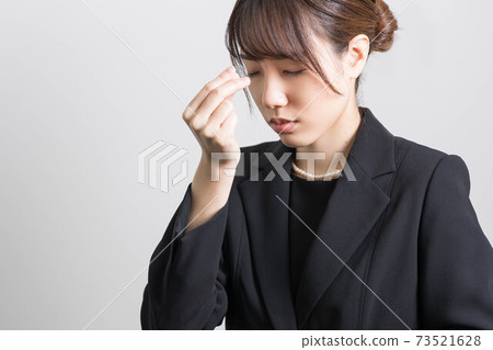 一個年輕女子在葬禮上燃燒的香火 73521628