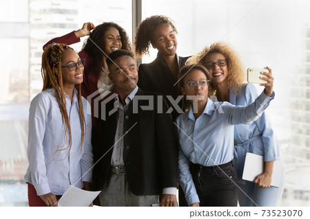 Smiling multiethnic colleagues male selfie on smartphone 73523070