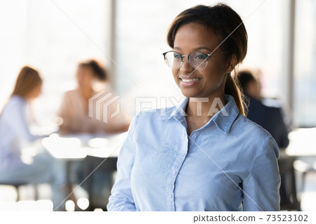 Smiling African American woman worker look in distance thinking Smiling African American woman worker look in distance thinking 73523102