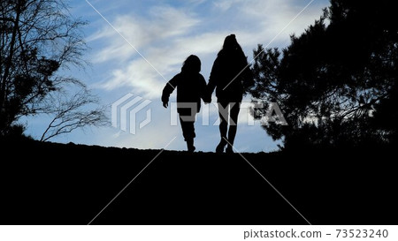 silhouettes of a boy and a girl sky against a blue sky in sunset during the lockdown due to the coronavirus measures silhouettes of a boy and a girl sky against a blue sky in sunset during the lockdown due to the coronavirus measures 73523240