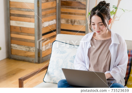 年輕女子坐在沙發上和遠程辦公 年輕女子坐在沙發上和遠程辦公 73523639