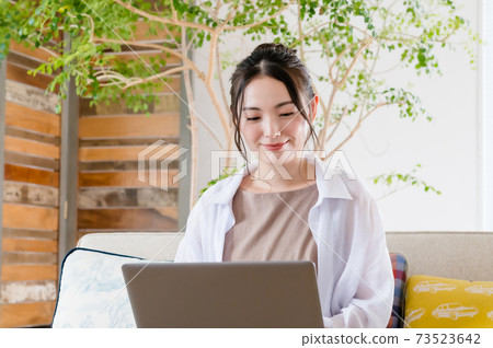 年輕女子坐在沙發上和遠程辦公 年輕女子坐在沙發上和遠程辦公 73523642