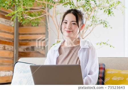年輕女子坐在沙發上和遠程辦公 年輕女子坐在沙發上和遠程辦公 73523643
