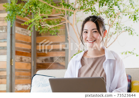 年輕女子坐在沙發上和遠程辦公 年輕女子坐在沙發上和遠程辦公 73523644