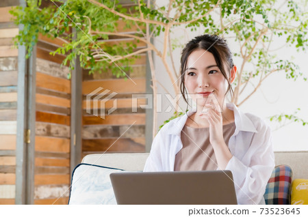 年輕女子坐在沙發上和遠程辦公 年輕女子坐在沙發上和遠程辦公 73523645