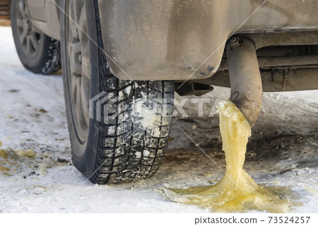 frozen yellow water condensate with gasoline from the exhaust pipe of a car frozen yellow water condensate with gasoline from the exhaust pipe of a car 73524257