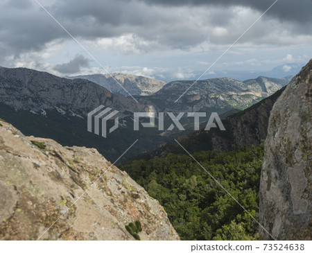 View of Gola Su Gorropu gorge, famous hiking destinantion at green forest landscape of Supramonte Mountains with limestone rock and mediterranean vegetation, Nuoro, Sardinia, Italy. Summer cloudy day 73524638