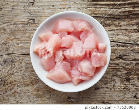 Raw cut chicken fillet in white bowl, from above Raw cut chicken fillet in white bowl, from above 73526008
