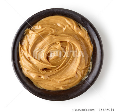 Peanut butter in round dish isolated on white background 73526014