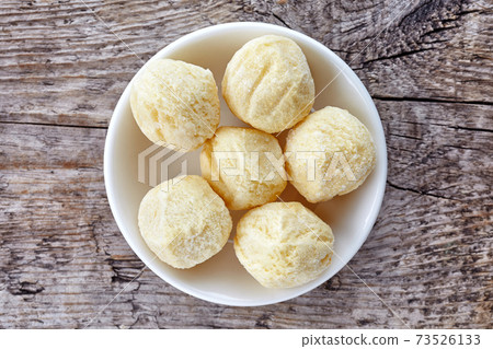 Bowl of frozen potato balls on wood, from above 73526133