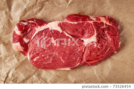 Raw beef steak on recycling paper, from above 73526454