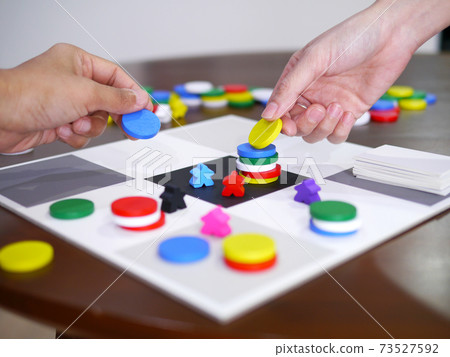 people playing fun board game on wooden table top selected focus 73527592