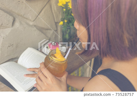 Asian woman reading book and drinking tea Asian woman reading book and drinking tea 73528757